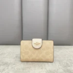 ⁦محفظة كوتش نسائية بتصميم سيجنتشر باللون البيج الفاتح، مع تفاصيل جلدية باللون الأبيض⁩ - الصورة ⁦3⁩